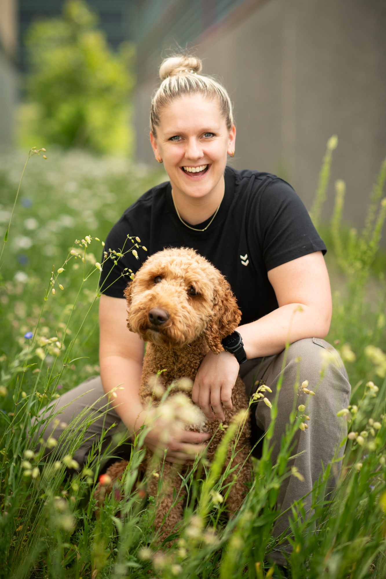 Esmee met haar hond buiten tussen het groen.